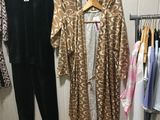 three women ' s clothing hanging on a rack in a clothing store