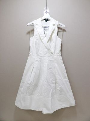 une photo d'une robe blanche suspendue à un cintre