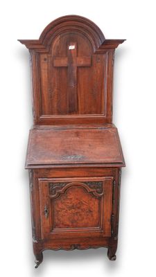 une vieille armoire en bois surmontée d'une croix
