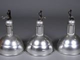 trois lampes en métal argenté sur fond gris