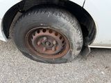 a dirty tire on the side of a white car