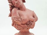statue of a woman holding a bunch of grapes on a pedestal