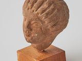 sculpture of a woman ' s head on a wooden stand