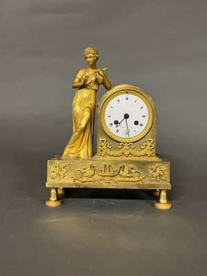 une horloge en or surmontée d'une statue