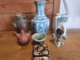 de nombreux vases de toutes sortes posés sur une table, à côté d'une coque de téléphone