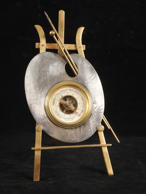 an image of a silver and gold clock on a wooden stand