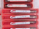six red pens are lined up in a row on a white surface