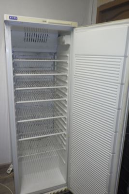 un réfrigérateur blanc dont la porte est ouverte, dans une pièce