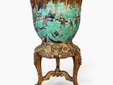 un vase vert posé sur une chaise en bois