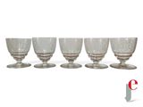 six wine glasses sitting on top of each other on a white surface