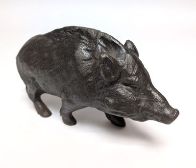 a small statue of a boar on a white surface