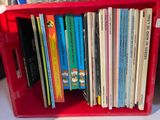 une boîte rouge contenant tout un tas de livres pour enfants