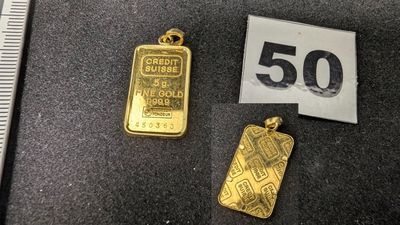 un gros plan d'un lingot d'or à côté d'un lingot d'or de 50 grammes