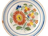 a plate with flowers painted on it on a white background