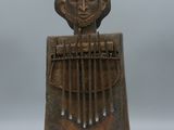 une sculpture en bois représentant une femme tenant un instrument de musique