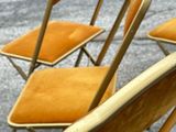 several chairs are lined up in a row on the pavement