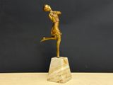 statue of a woman holding a tennis racquet on a marble base
