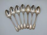six silver spoons are lined up in a row on a table