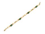 un bracelet en or orné de pierres vertes