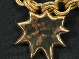gold plated necklace with a starburst pendant on a gold chain