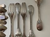 several spoons, forks and spoon spoons are arranged on a table