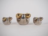 three pieces of silver and gold metal sitting next to each other