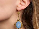 the woman is wearing a pair of earrings with a picture of a man and a woman