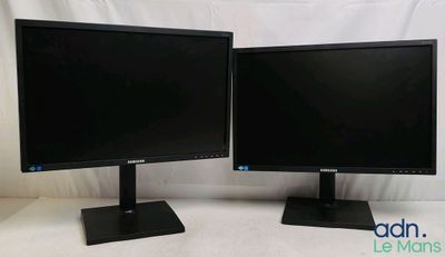 two computer monitors sitting side by side on a white surface