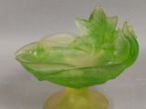 un bol en verre vert contenant une feuille verte