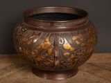 an image of a large bronze pot sitting on top of a wooden table