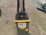 un aspirateur gris et jaune posé sur le sol
