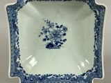 blue and white plate with flowers on it on a metal stand