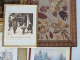 many framed pictures on the wall of this room