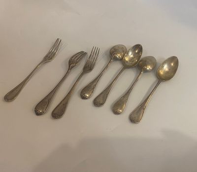 six silver spoons and a fork on a white surface