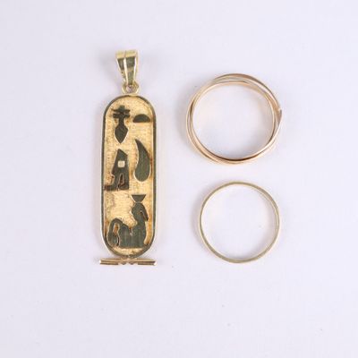 two gold rings and a gold pendant with a picture of a man and a woman