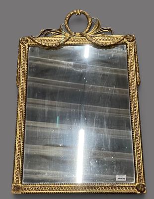 an ornate gold framed mirror hanging on a wall in a room
