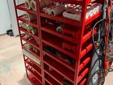 un porte-vêtements rouge sur lequel sont posés des rouleaux de tissu
