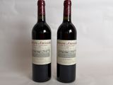 two bottles of red wine sitting on top of a white table