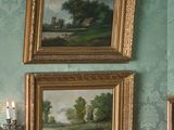 deux tableaux accrochés au mur au-dessus d'un miroir