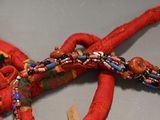 a close up of a red necklace with beads on it