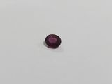 a close up of a purple gemstone on a white surface