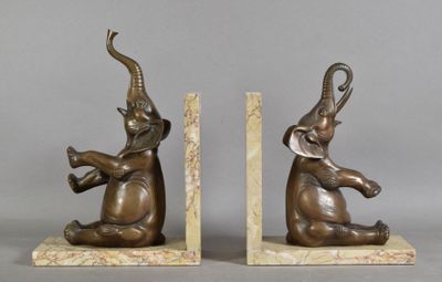 pair of bronze elephants on marble bookends on grey background