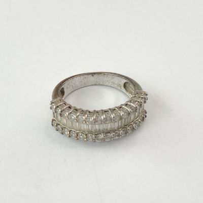 gros plan d'une bague en argent sur une surface blanche