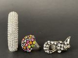 three pieces of jewelry are sitting on a black surface