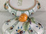 an orange sitting on top of a decorative bowl