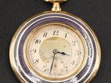 an image of a gold pocket watch on a black surface