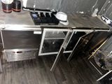 une cuisine avec de nombreux appareils électroménagers en inox posés sur le plan de travail