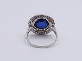 a close up of a ring with a blue stone in it