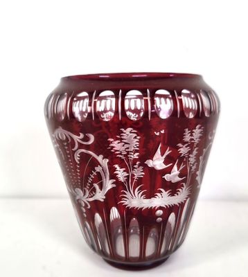a red vase with white designs on it on a white surface