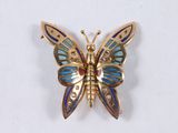 butterfly shaped brooch with blue and yellow enamel wings on a white background